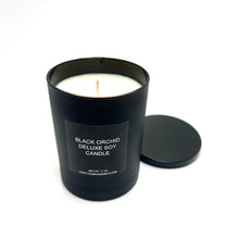 Chic and luxurious Black Orchid Deluxe Soy Candle, inspired by Tom Ford, illuminating a modern tabletop.