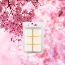 Cherry Blossom Soy Wax Melts displayed in a decorative dish, with the soft pink hues of cherry blossoms surrounding them, emphasizing their floral and fruity fragrance.
