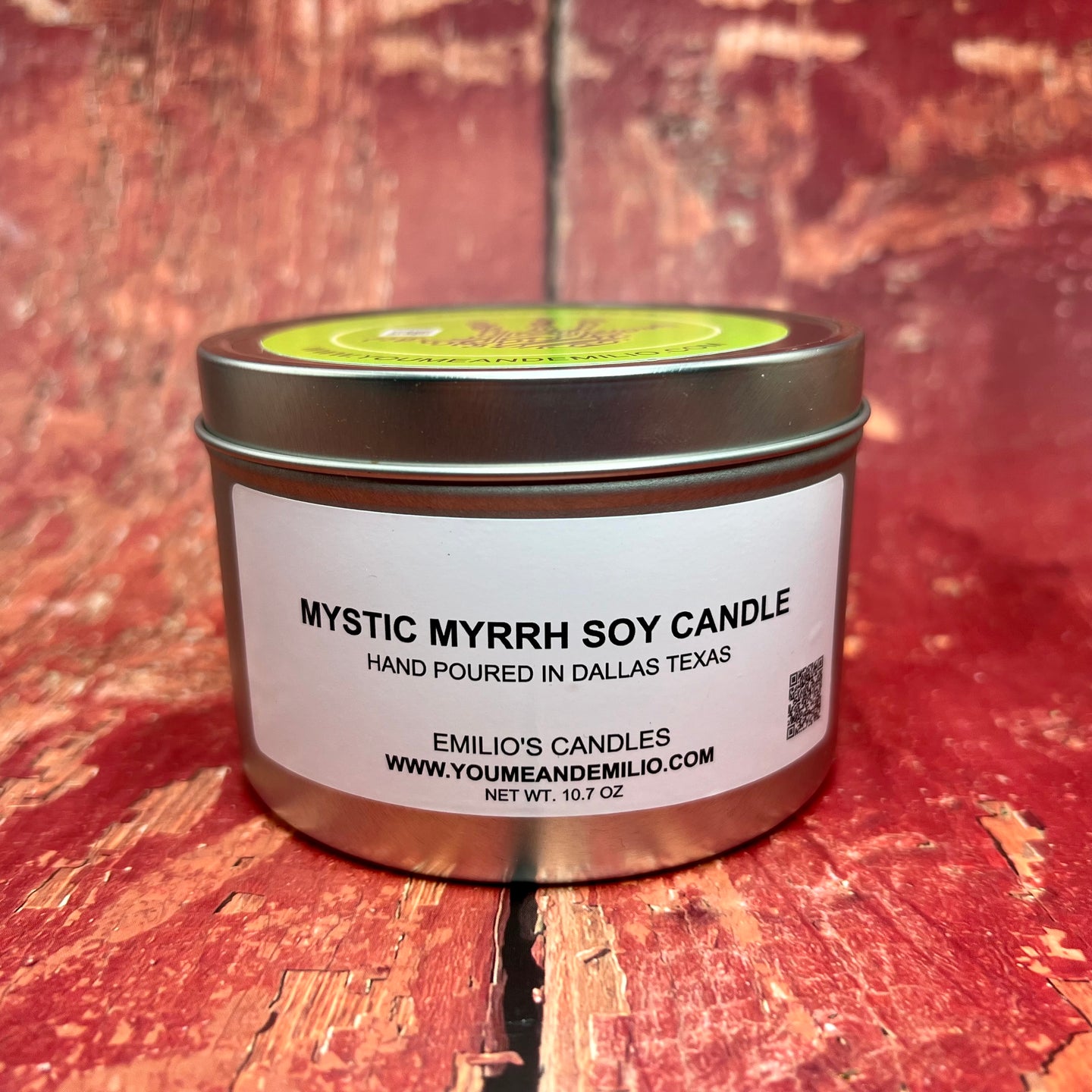 A hand-poured Mystic Myrrh Soy Candle in a matte black jar with a wooden wick, exuding a warm and inviting glow as it fills the room with a rich, earthy scent.